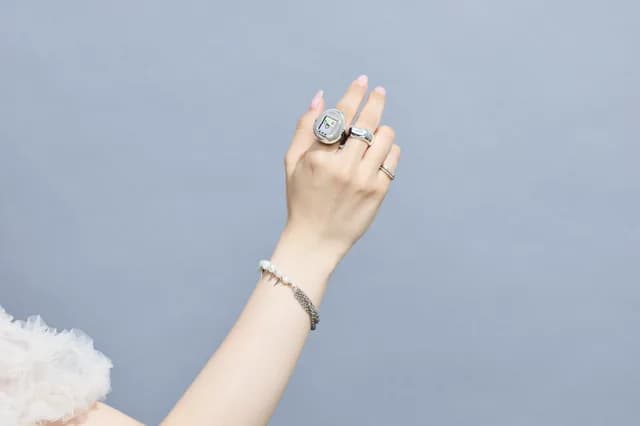 Drei Varianten des Tamagotchi ring in Rosa, Weiß-Blau und Schwarz mit kleinen Farbdisplays